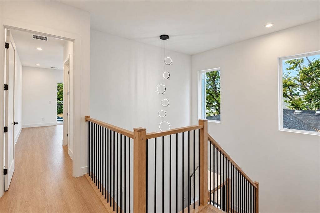 314 Avenue L, Dallas, TX 75203 Contemporary pendant lighting, wood-finish flooring, staircase with natural wood railing, black metal balusters, and recessed ceiling lights