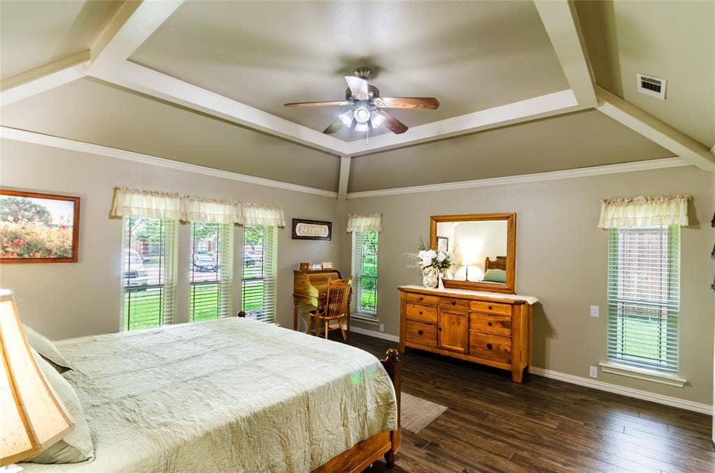 4009 Wilshire Court, Plano, TX 75023 Tray ceiling with crown molding, wood-finish flooring, and multiple windows with blinds