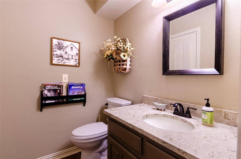 4009 Wilshire Court, Plano, TX 75023 Bathroom vanity featuring a light-toned countertop, undermount sink, and dark bronze-finish faucet