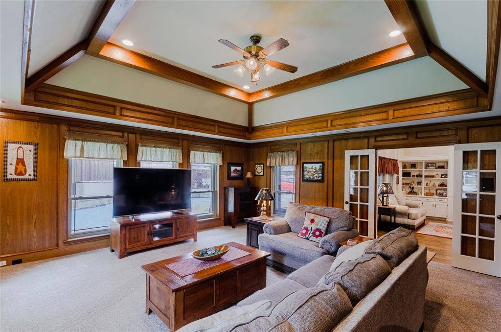 4009 Wilshire Court, Plano, TX 75023 Living area featuring wood paneling, a tray ceiling with wood beams, recessed lighting, and a ceiling fan