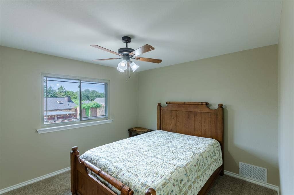 4009 Wilshire Court, Plano, TX 75023 Neutral wall paint, ceiling fan with integrated lighting, window with white trim, and light brown carpeting