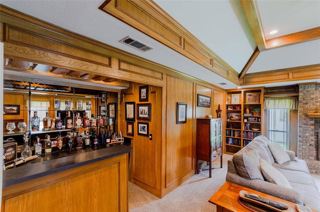 4009 Wilshire Court, Plano, TX 75023 Custom built-in bar with dark countertop and mirrored back wall