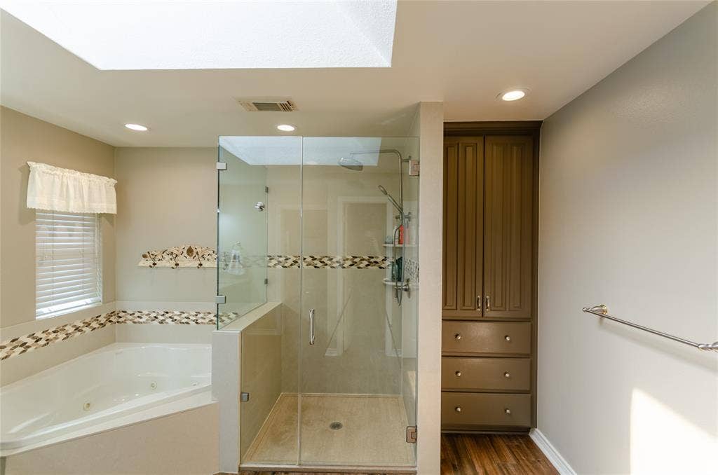 4009 Wilshire Court, Plano, TX 75023 Glass-enclosed shower, built-in soaking tub, skylight, recessed lighting, and integrated cabinetry with drawers
