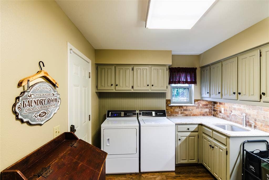 4009 Wilshire Court, Plano, TX 75023 Dedicated utility room featuring wood-finish flooring, light-toned cabinetry, a built-in sink with a countertop, and a tiled backsplash