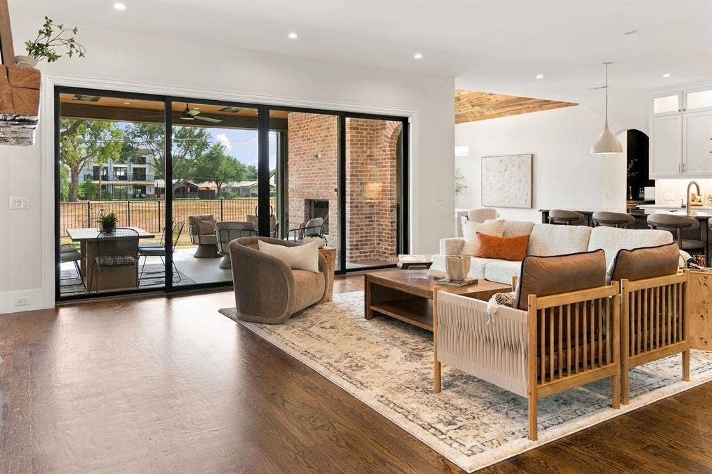 3368 Dorado Beach Drive, Farmers Branch, TX 75234 Expansive living area featuring wood-finish flooring, recessed lighting, and a brick-clad fireplace