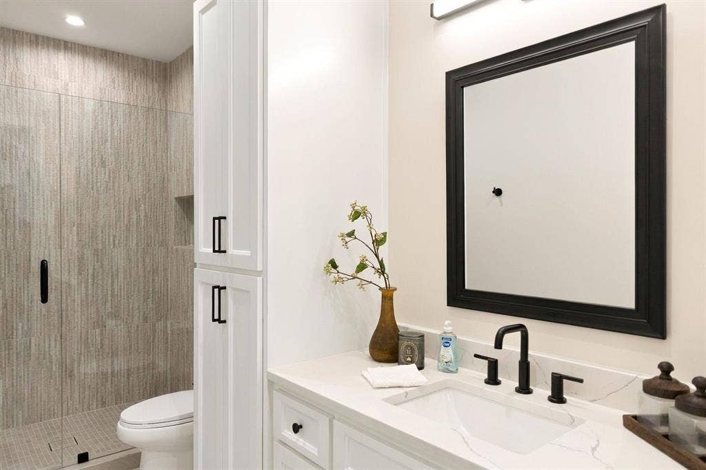 3368 Dorado Beach Drive, Farmers Branch, TX 75234 White shaker-style cabinetry with matte black hardware, stone-finish countertop, and undermount sink
