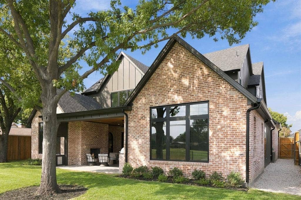 3368 Dorado Beach Drive, Farmers Branch, TX 75234 Brick exterior with black-framed windows, a covered patio, and a gravel walkway