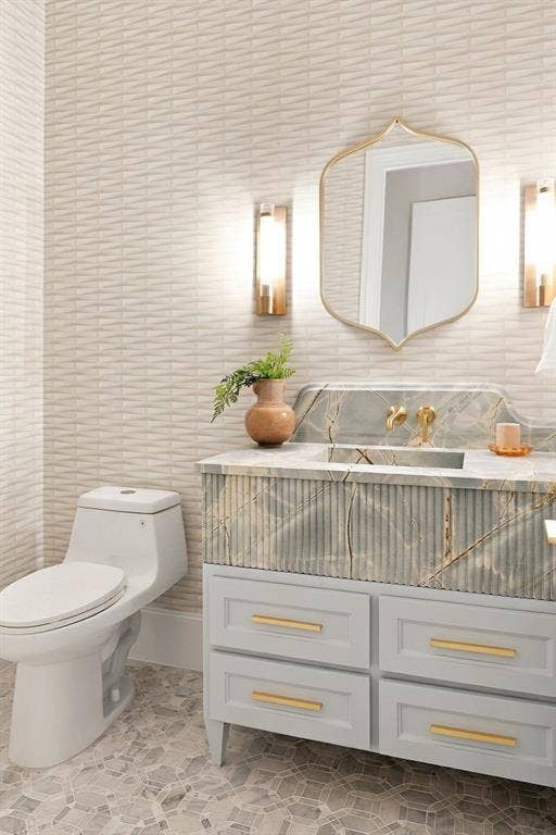 3368 Dorado Beach Drive, Farmers Branch, TX 75234 Textured wall tiling, custom vanity with fluted detailing, integrated sink basin, gold-finish hardware, and geometric floor tiling