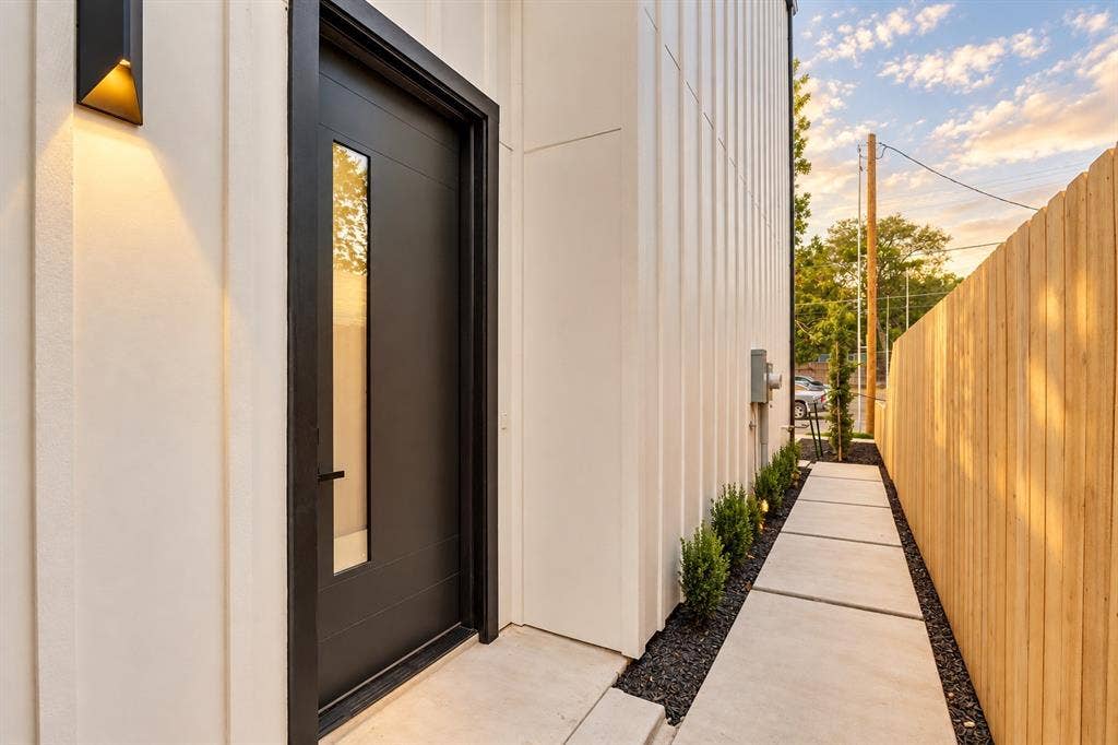 316 Avenue L, Dallas, TX 75203 Modern exterior with vertical siding and a dark entry door featuring an integrated vertical window panel