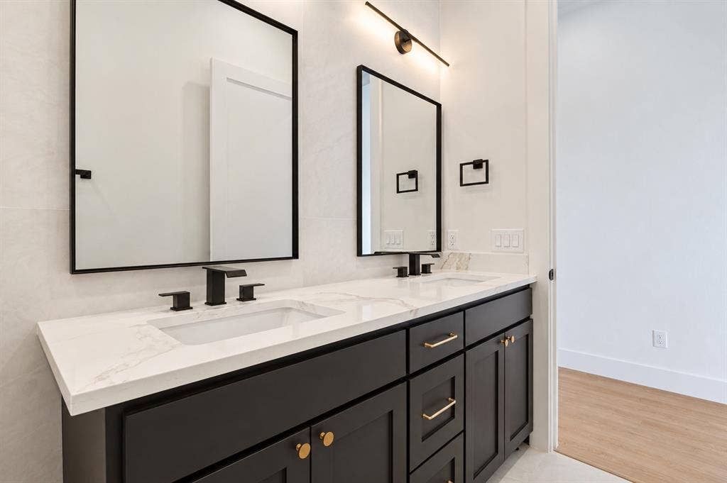 314 & 316 Avenue L, Dallas, TX 75203 Dual vanity with integrated sinks, white countertop, black cabinetry, and gold-tone hardware
