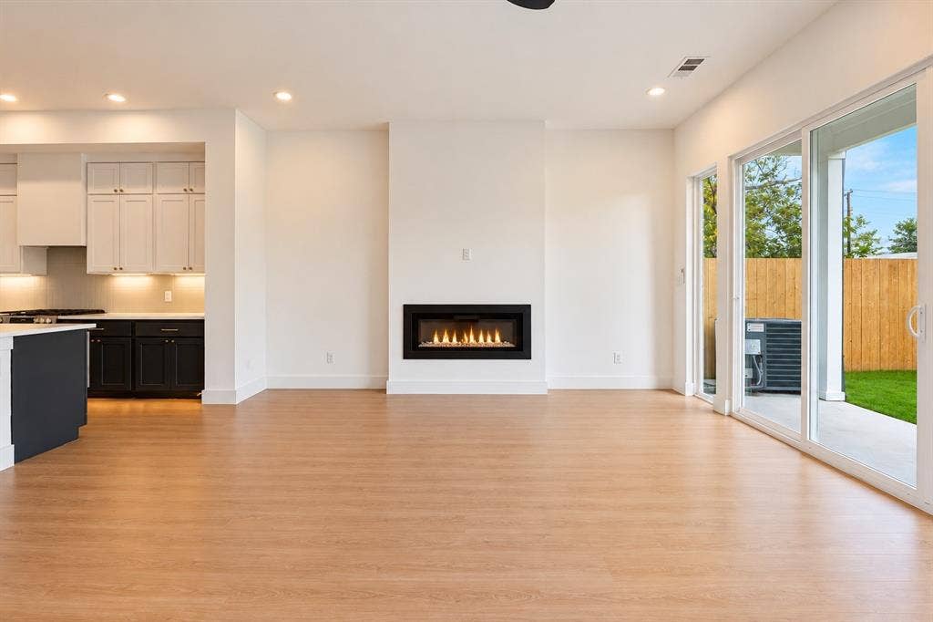 314 & 316 Avenue L, Dallas, TX 75203 Wood-finish flooring, built-in linear fireplace, recessed lighting, and kitchen with light and dark cabinetry