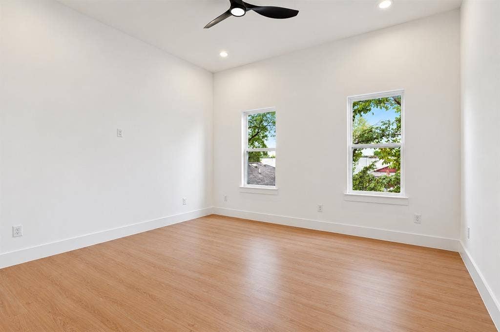 314 & 316 Avenue L, Dallas, TX 75203 Light wood-finish flooring, two large windows, white walls, recessed lighting, and a ceiling fan