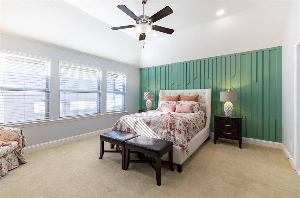 Spacious primary suite with accent wall and wall of windows for natural light.
