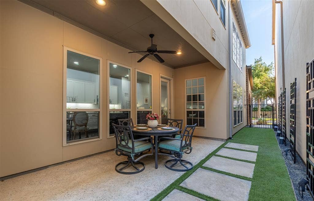 Covered patio and gated yard with turf.