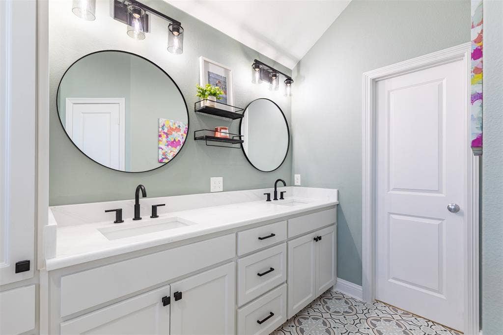 En-suite bath features large vanity with framed mirrors.