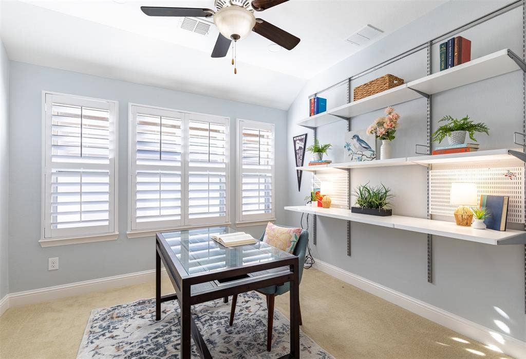 Private office with plantation shutters and built-in shelving.