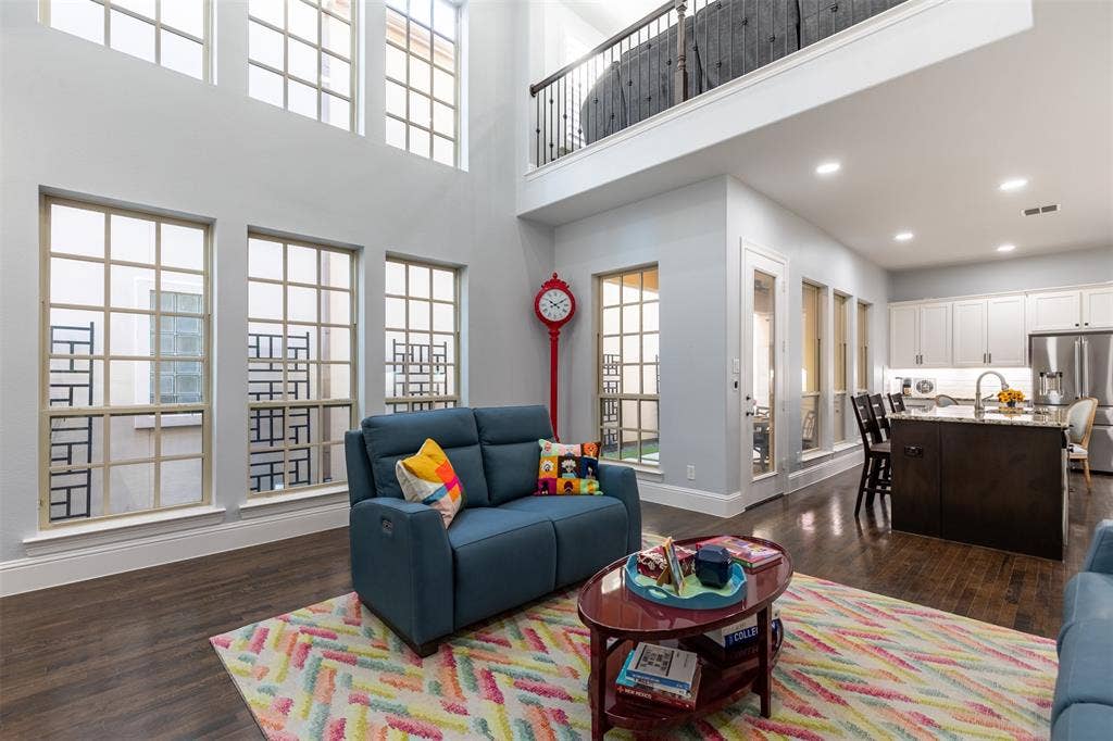 Living room with stacked windows providing natural light.