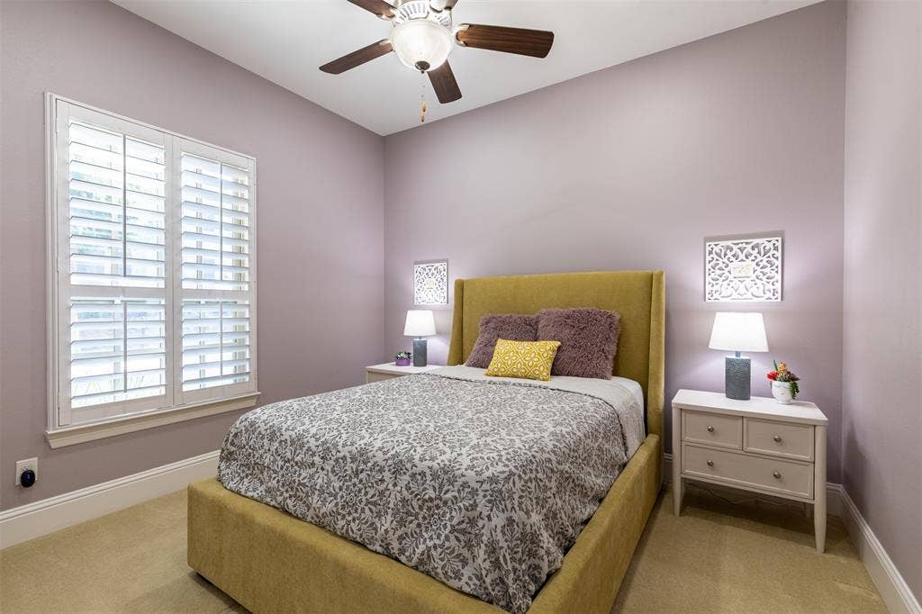 Downstairs guest suite with ceiling fan and plantation shutters.