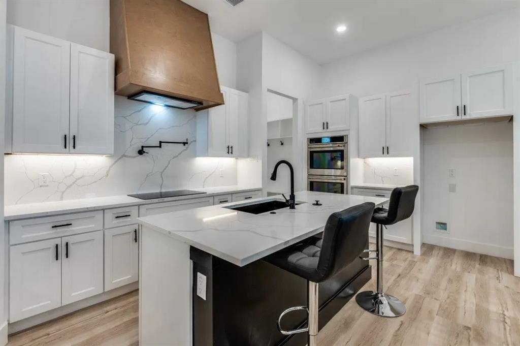 2802 Guymon Street, Dallas, TX 75212 Spacious kitchen featuring white shaker cabinetry and a wood-finish range hood