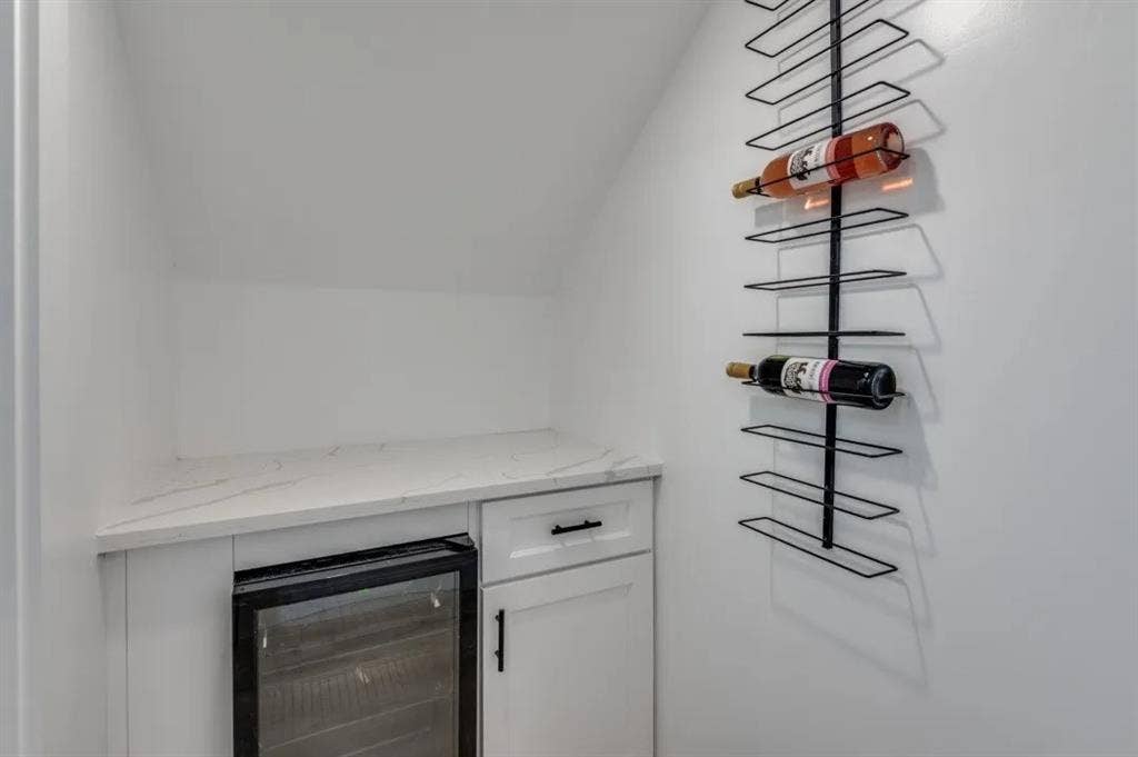 2802 Guymon Street, Dallas, TX 75212 Built-in beverage cooler, white cabinetry, quartz countertop, and wall-mounted wine rack