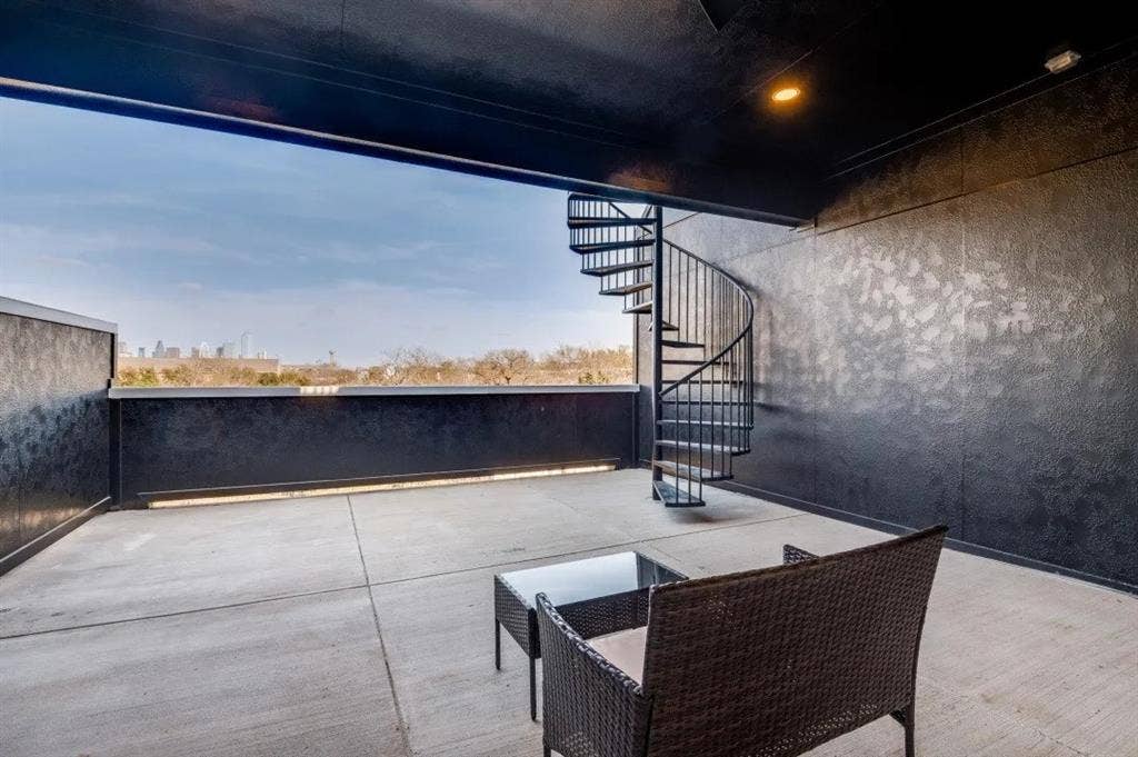 2802 Guymon Street, Dallas, TX 75212 Expansive outdoor terrace featuring concrete flooring, a black spiral staircase, and textured wall finishes