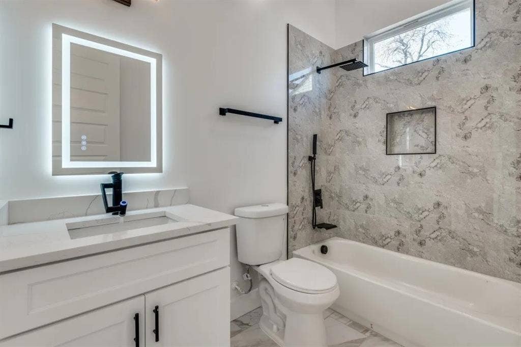 2802 Guymon Street, Dallas, TX 75212 Vanity with integrated sink, illuminated mirror, and matte black fixtures