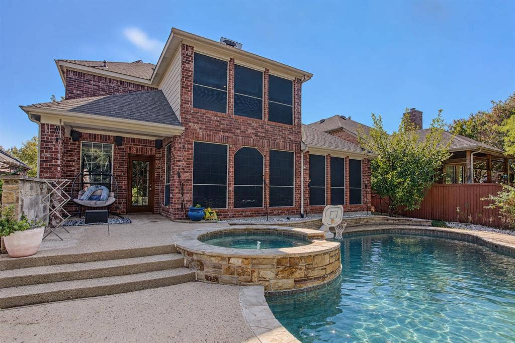 1905 Canyon Wren Drive, McKinney, TX 75071 Private backyard retreat with greenbelt views, a pool and raised spa, expansive concrete decking, and mature landscaping. Photo taken right after a few days of heavy thunderstorms and rain while the pool was undergoing maintenance. Water shown in the pool and spa has been digitally added.