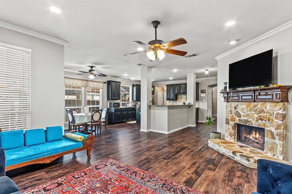 1905 Canyon Wren Drive, McKinney, TX 75071 Open-concept floor plan featuring wood-style flooring, a stone fireplace with a wood mantle, recessed lighting, and a ceiling fan