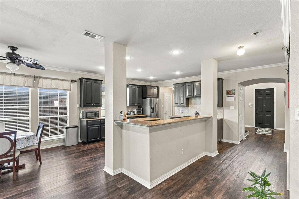 1905 Canyon Wren Drive, McKinney, TX 75071 Open-concept floor plan featuring wood-style flooring, kitchen with cabinetry and countertops, recessed lighting, and crown molding
