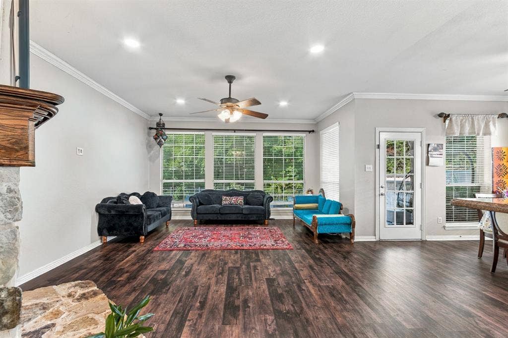 1905 Canyon Wren Drive, McKinney, TX 75071 Wood-style flooring, stone-clad fireplace with wood mantel, multiple windows with blinds, ceiling fan with integrated lighting, recessed ceiling lighting