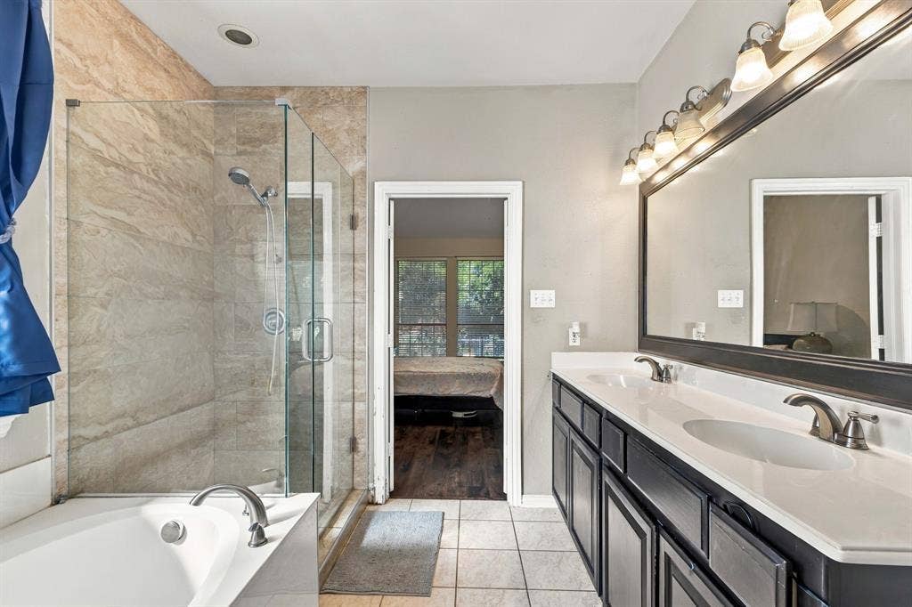 1905 Canyon Wren Drive, McKinney, TX 75071 Master bath with dual-sinks, soaking tub, separate shower area base cabinetry with ample storage, and a large framed mirror