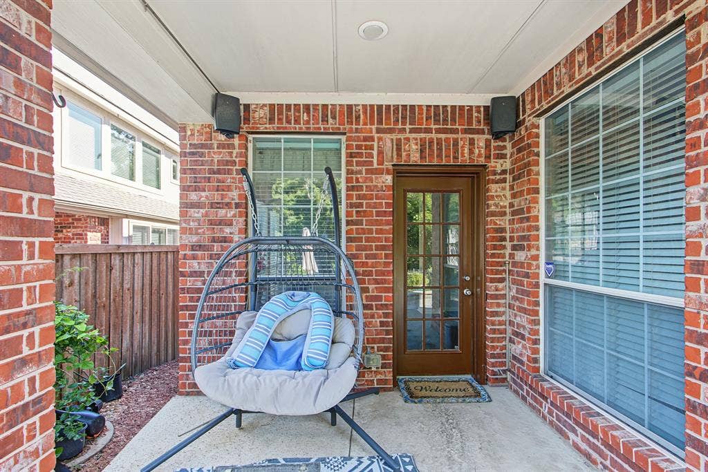 1905 Canyon Wren Drive, McKinney, TX 75071 Covered patio with brick siding, concrete flooring, and a glass-paneled door