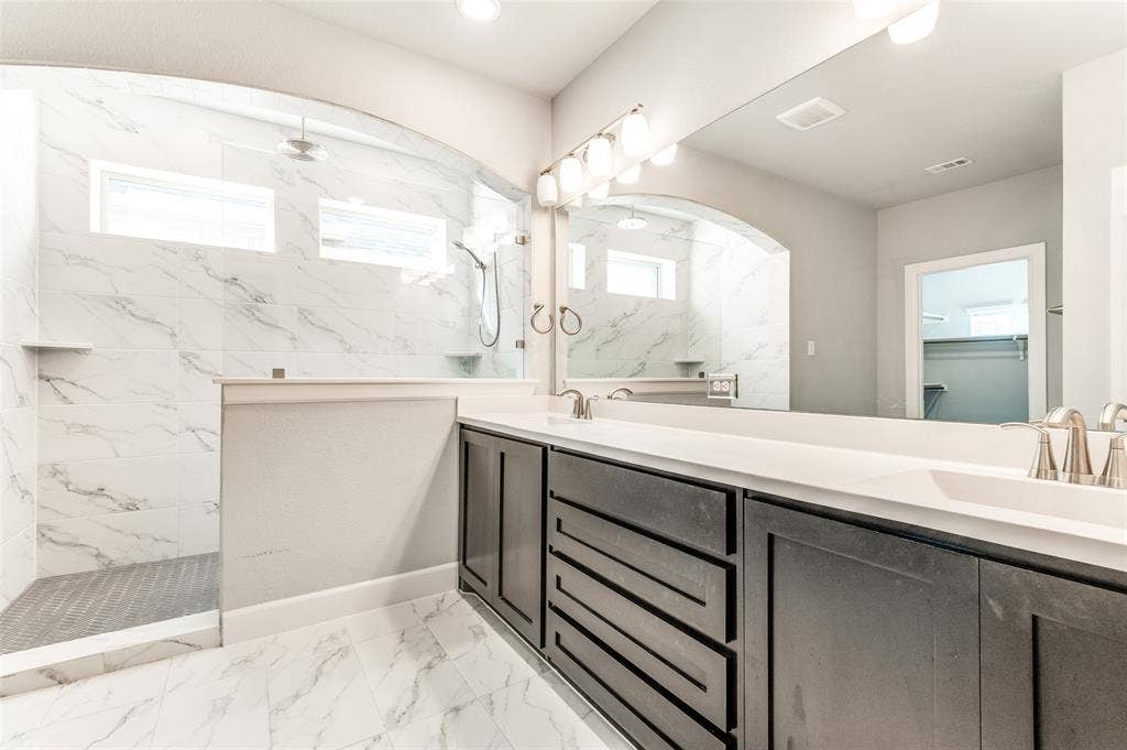 636 Courtyard Lane, Irving, TX 75039 Dual vanity with dark wood-finish cabinetry, white countertop, and brushed nickel fixtures