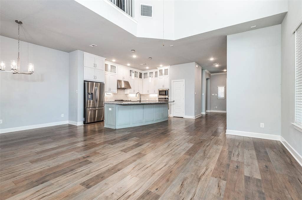 636 Courtyard Lane, Irving, TX 75039 Wood-finish flooring throughout, kitchen with stainless steel appliances, central island with seating, pendant lighting, and recessed lighting