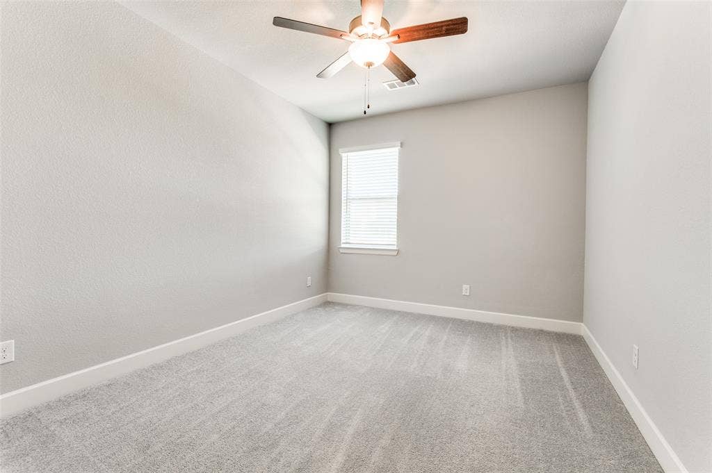 636 Courtyard Lane, Irving, TX 75039 Neutral-toned wall finishes, light gray carpet, and a ceiling fan with integrated lighting