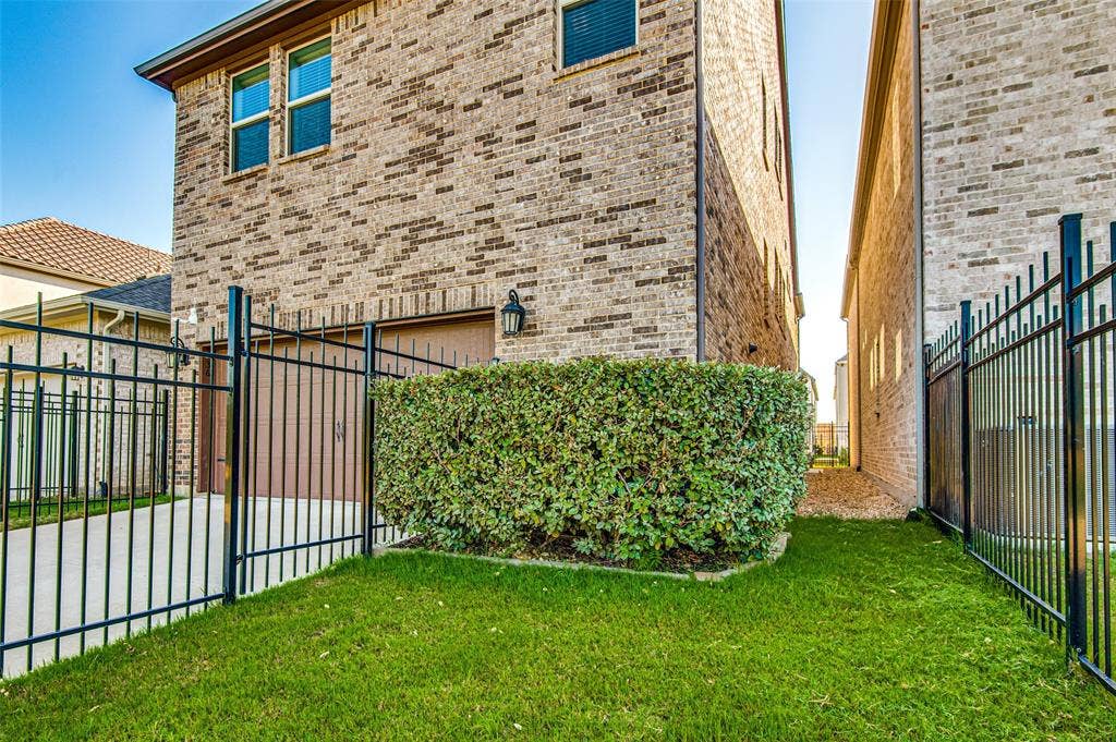 636 Courtyard Lane, Irving, TX 75039 Brick exterior with multiple windows, an enclosed garage, and a manicured lawn