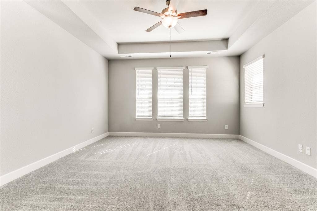 636 Courtyard Lane, Irving, TX 75039 Light gray carpeting, a tray ceiling, and a ceiling fan with light fixture