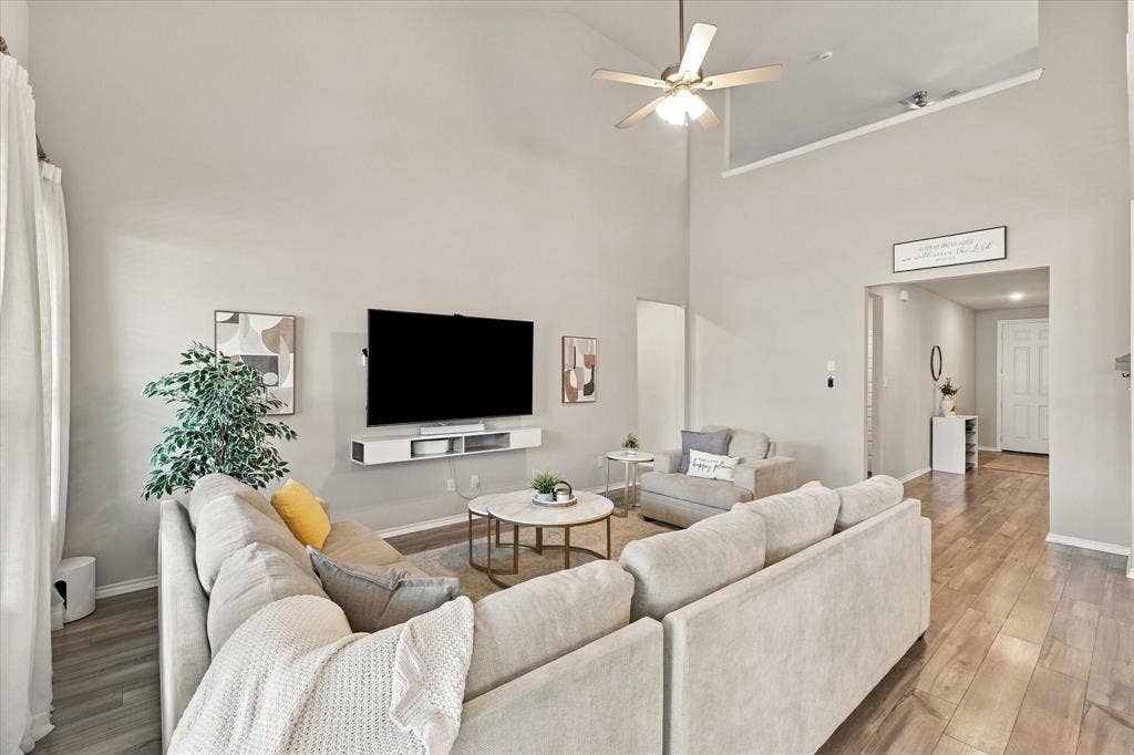 6304 Jib Court, Fort Worth, TX 76179 Vaulted ceiling with a ceiling fan, wall-mounted media console, and wood-finish flooring
