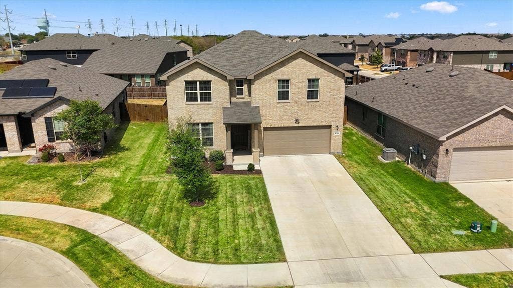 6304 Jib Court, Fort Worth, TX 76179 Two-story brick exterior with a two-car garage, concrete driveway, and front lawn