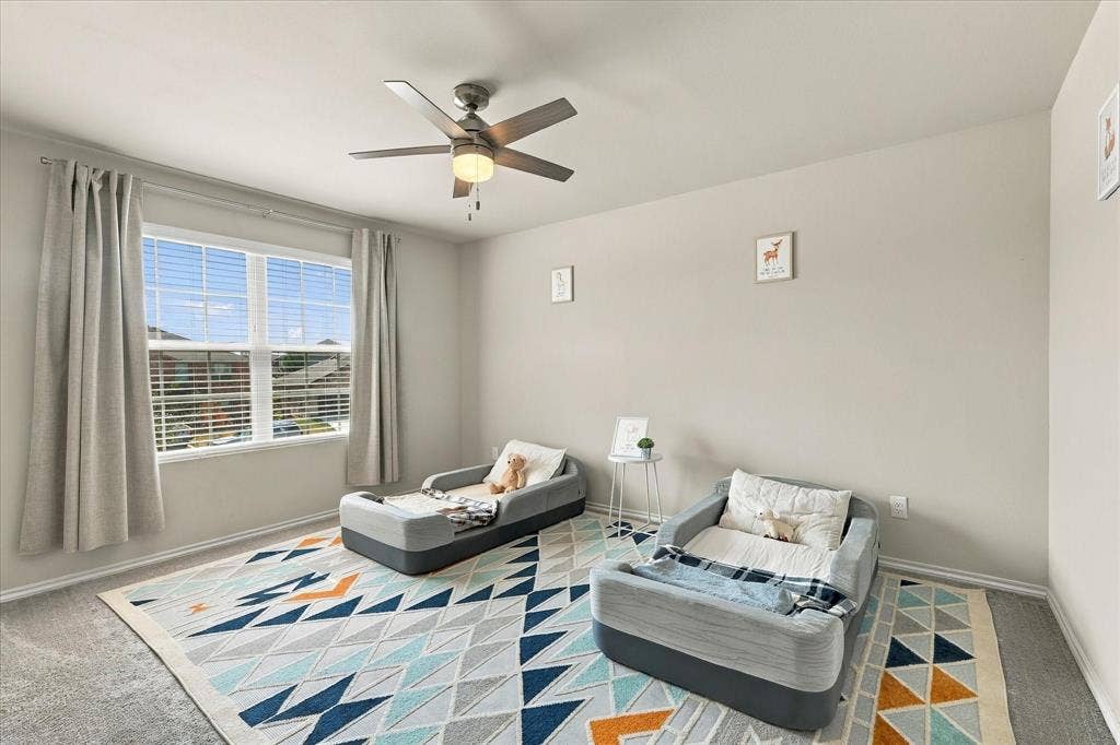 6304 Jib Court, Fort Worth, TX 76179 Window with horizontal blinds, overhead ceiling fan with lighting, light gray wall paint, and gray carpet