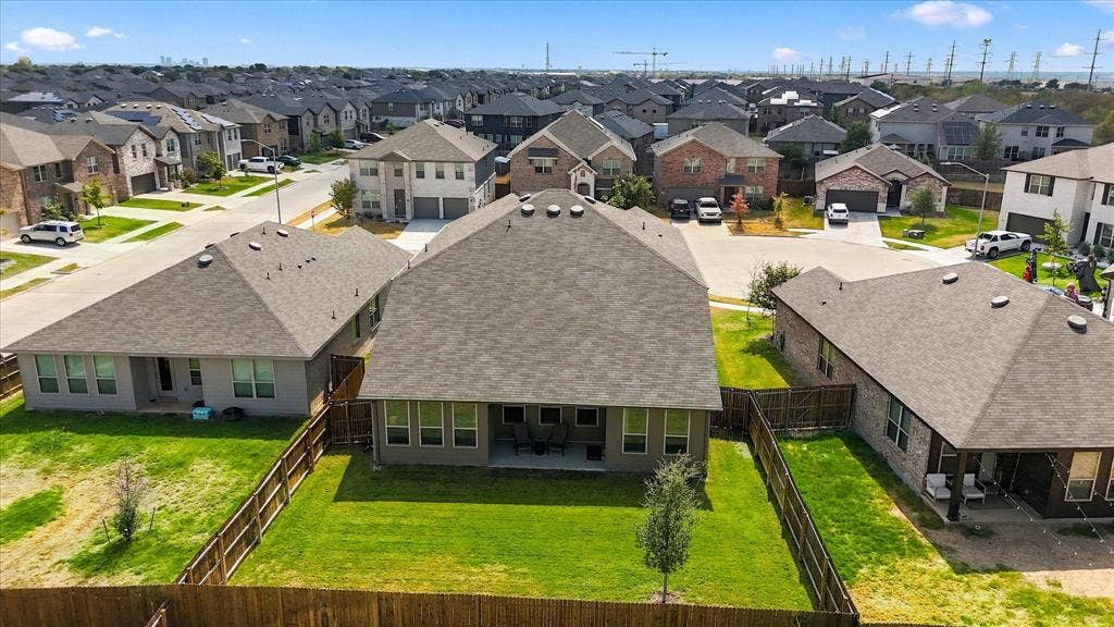 6304 Jib Court, Fort Worth, TX 76179 Expansive fenced backyard with a manicured lawn, established tree, and covered patio