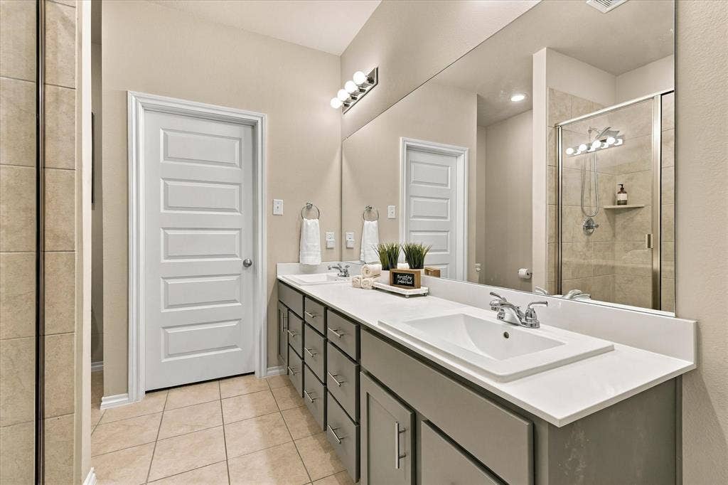 6304 Jib Court, Fort Worth, TX 76179 Dual vanity with an expansive counter, full-width mirror, and chrome fixtures