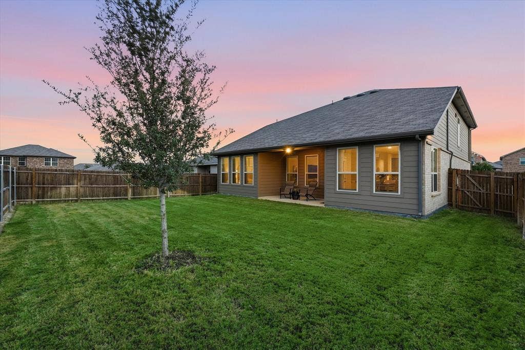 6304 Jib Court, Fort Worth, TX 76179 Expansive backyard with a manicured lawn, established tree, and wood privacy fencing