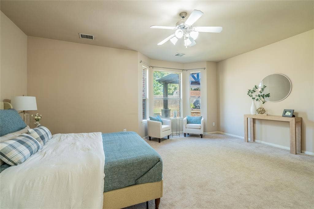 Primary bedroom with  recessed lighting, ceiling fan with light fixture, bay window, carpet flooring, and neutral wall paint