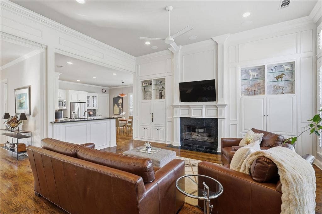 5600 Southern Hills Drive, Frisco, TX 75034 A fireplace with a floor-to-ceiling mantel surround and built-in cabinetry anchors the room, adding warmth and architectural interest.
