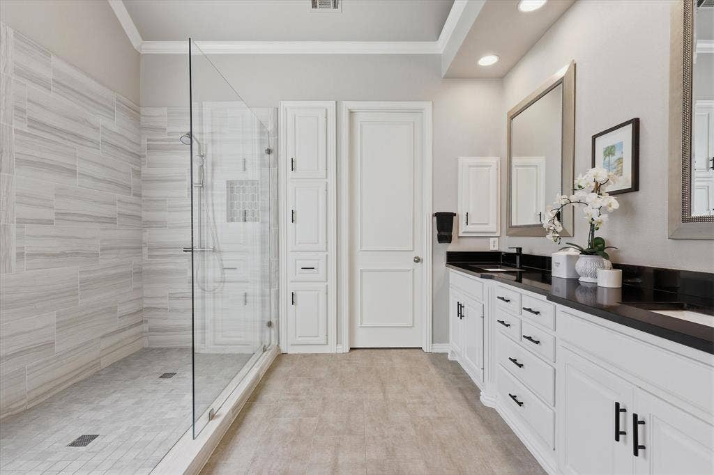 5600 Southern Hills Drive, Frisco, TX 75034 A massive glass-enclosed shower, dual sinks and abundant storage continue the clean-lined feel in the well-appointed primary bath.