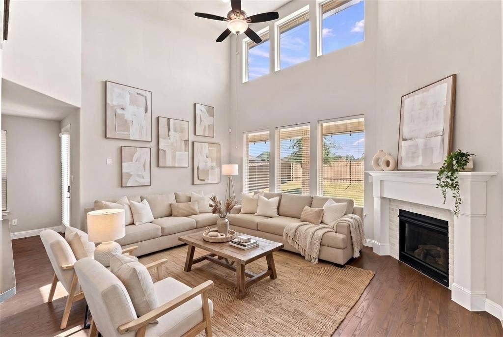 Soaring vaulted ceilings and abundant natural light define this expansive living room, anchored by gas fireplace. (Virtually staged photo)