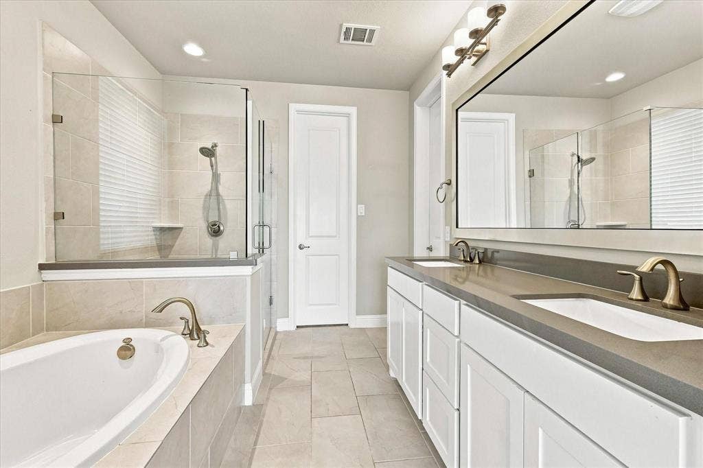 Dual vanity, shower and bathtub in this generously sized primary bathroom