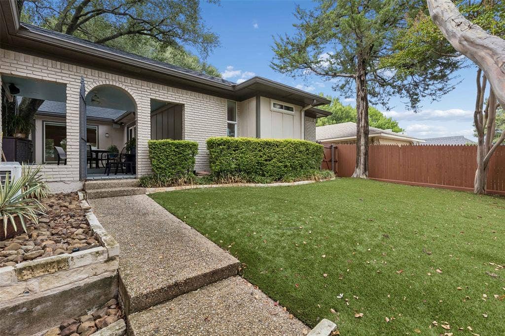 Easy Access Around the Backyard — A dedicated walkway connects the outdoor living areas with the turf yard, making the backyard feel organized, usable, and easy to navigate.