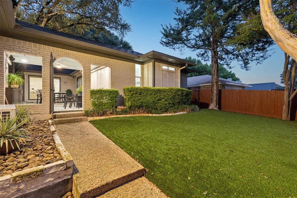 Private Backyard Retreat — A low-maintenance turf lawn, mature trees, privacy fencing, and easy access to the covered patio create an outdoor space designed for relaxing, entertaining, and everyday enjoyment.